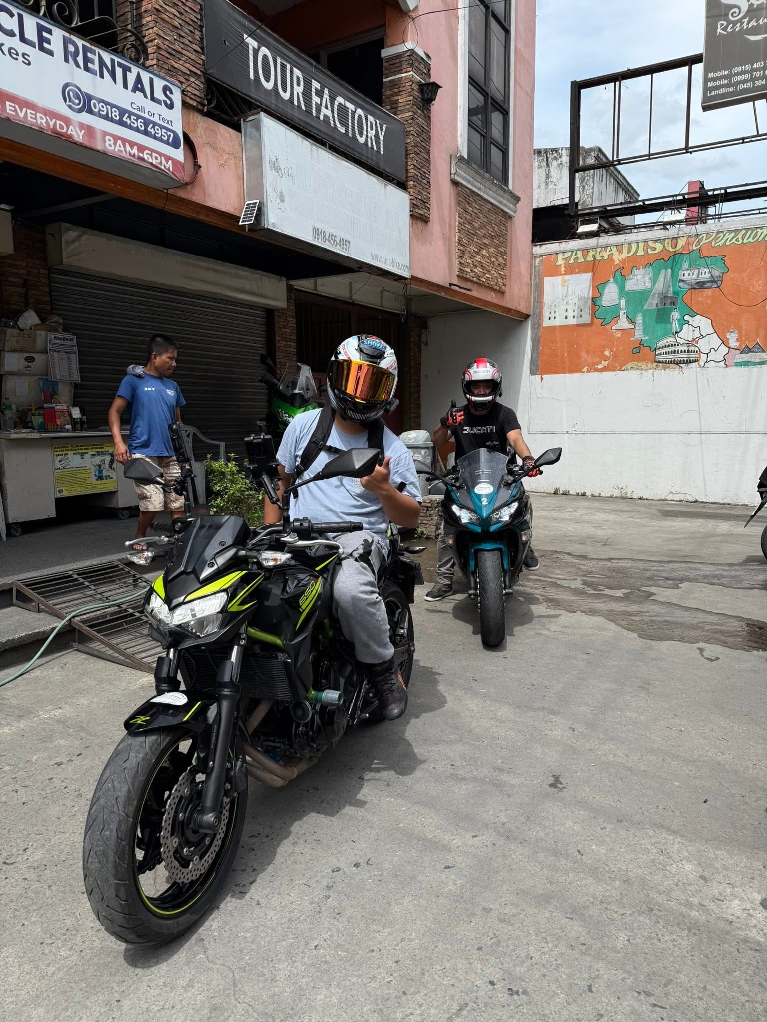 Two customers with motorcycles outside NiceBike
