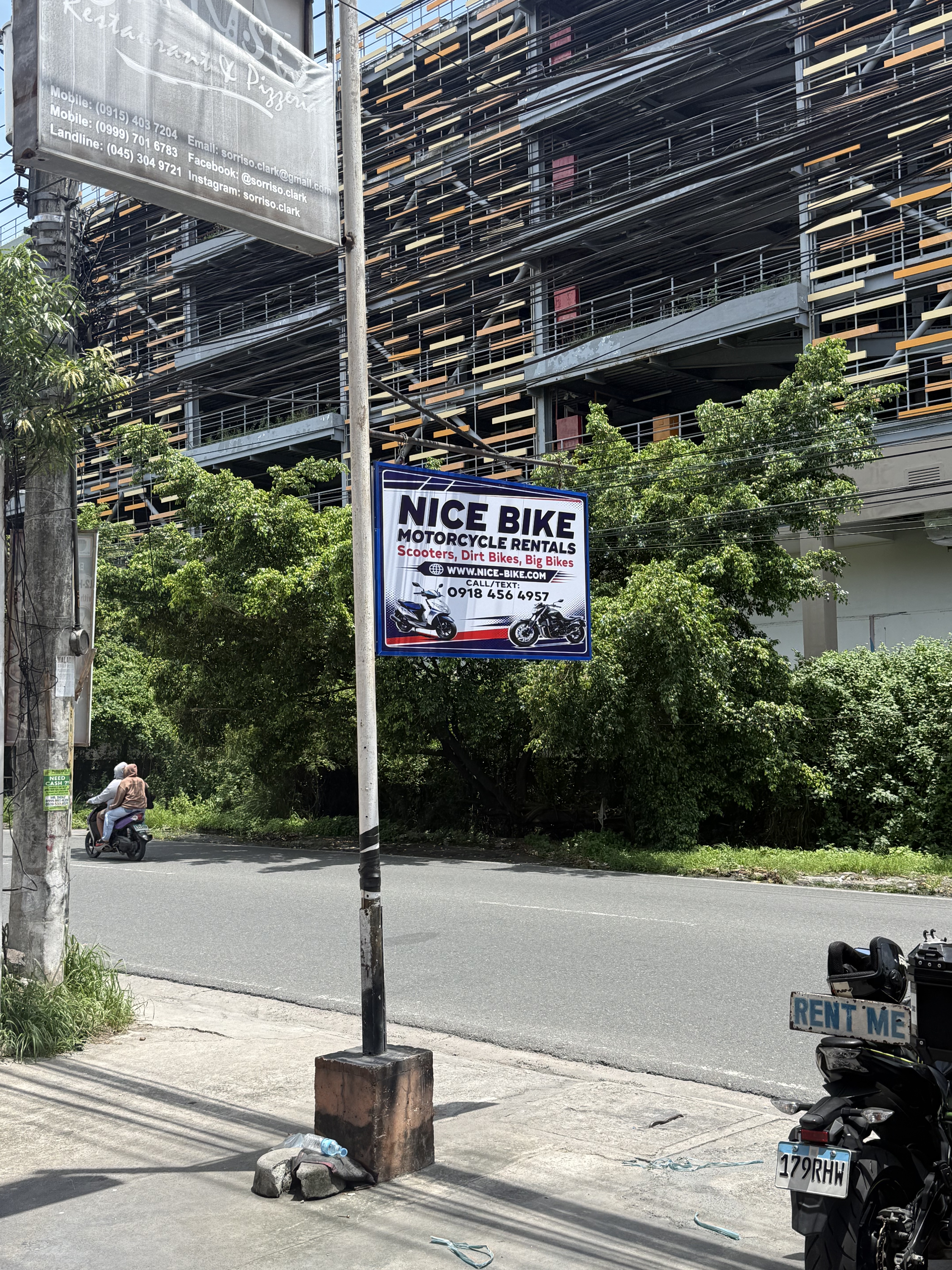 Nice Bike Motorcycle Rentals sign on the road in Angeles City